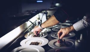 Chefs hands plating out restaurant food